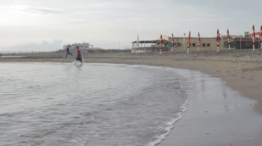 İki sevgili chase (çalıştırma) ve deniz - plaj - aşık - günbatımı öpüşme