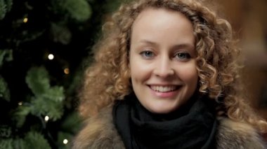 Kameraya gülümseyen mutlu kadın - arka planda Noel ağacı - KOLOR 1