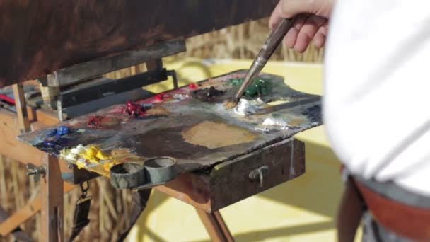 Malíř, míchání s barvami štětec — Stock video