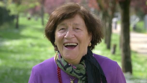 Porträt einer alten Frau, die lacht und in die Kamera blickt — Stockvideo