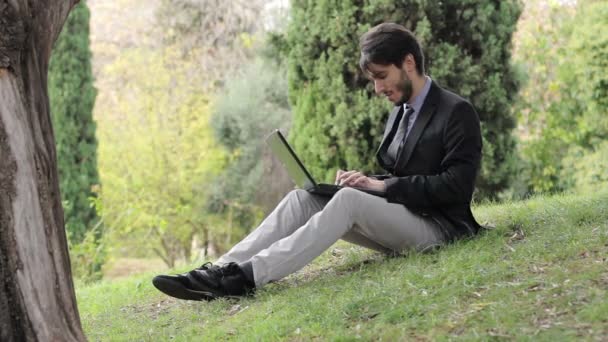 Junger Geschäftsmann sitzt mit Tablet — Stockvideo