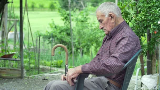 Starý muž odpočívat na židli — Stock video