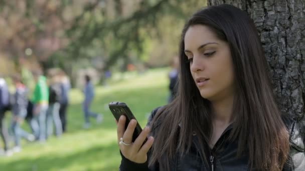 Menina bonita está respondendo involuntariamente ao telefone: smartphone, ao ar livre, chamada — Vídeo de Stock