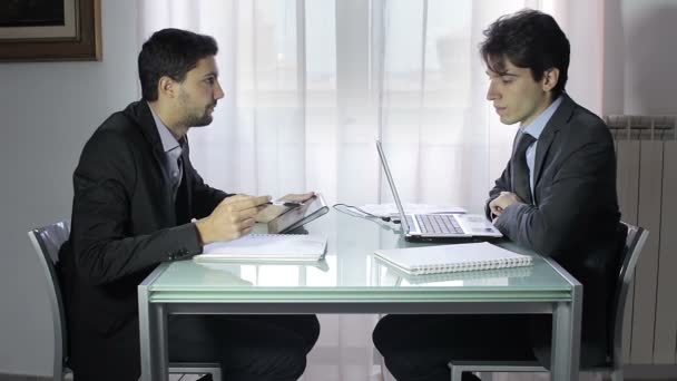 Dos hombres de negocios en trajes elegantes sentados en el escritorio trabajando en equipo juntos — Vídeo de stock