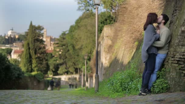 Jong koppel zoenen in de straat in de buurt van een oude muur in Rome — Stockvideo
