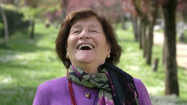 Happy old woman laughing and smiling in the park — Stock Video