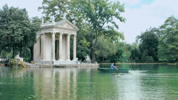 Pareja teniendo una excursión en el lago con un bote de remos en Roma, Villa borghese — Vídeo de stock