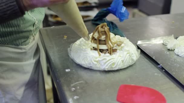 Pasticcere guarnire una torta con panna montata — Video Stock