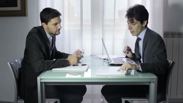 Dos jóvenes hombres de negocios en la reunión, dos hombres de negocios trabajando en el portátil — Vídeos de Stock