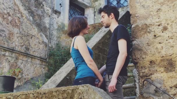 A szerelem: félénk nő magába foglal egy fiatal férfi a lépcsőn — Stock videók