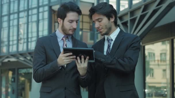 Spolupracovníky pomocí tabletu poblíž kanceláře: pracovní tým pomocí sociální sítě a web — Stock video