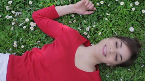 Bonita jovem mulher relaxante na primavera sobre a natureza: parque, grama, deitado — Vídeo de Stock