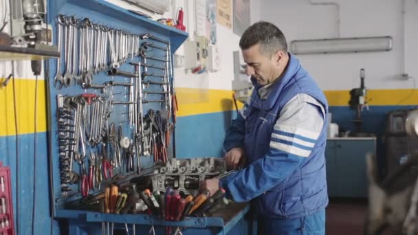 Mecánico de automóviles reparando una parte de un motor de coche — Vídeos de Stock