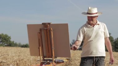 Mısır tarlasında ortasında ressam boyalar bir güzel manzara, tuval, şövale