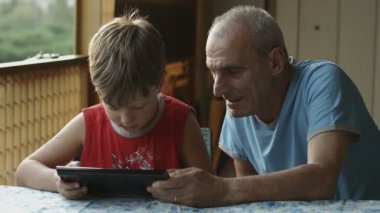 Dede ve torunu tablet bilgisayar kullanarak: Aile, çocuk, yaşlı