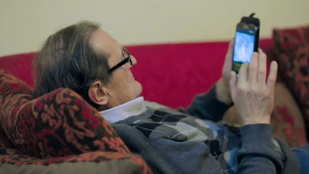 Een portret van een volwassen man texting met haar telefoon thuis — Stockvideo