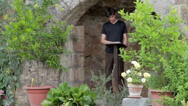 Man reading a book in garden — Stock Video