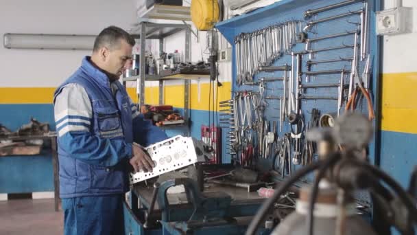 Mecánico de automóviles reparando una parte de un motor de coche — Vídeos de Stock