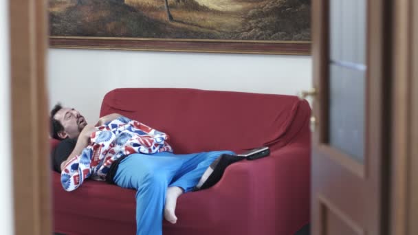 Мужчина спит на диване — стоковое видео