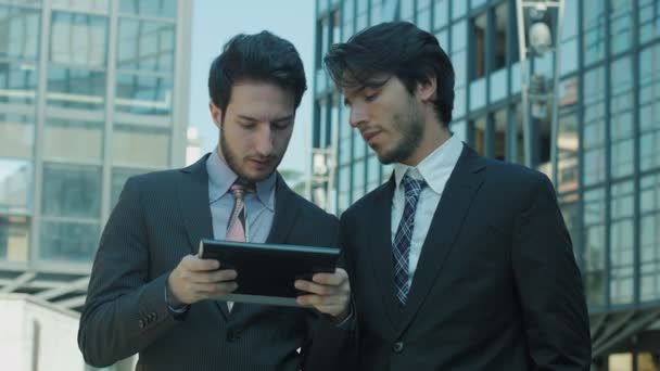 Hommes d'affaires utilisant une tablette informatique en dehors de leur bureau : travail, internet, entreprise — Video