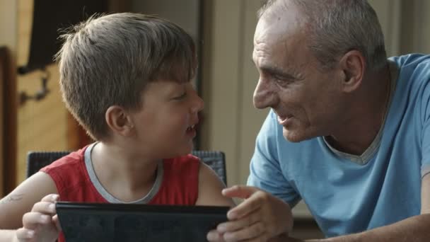 Παππούς και εγγονός χρησιμοποιώντας υπολογιστή tablet: οικογένεια, παιδιά, ηλικιωμένους — Αρχείο Βίντεο