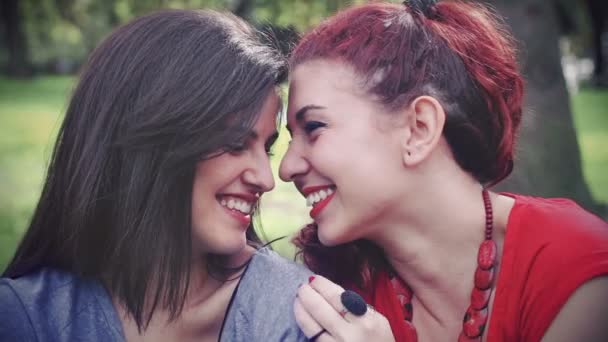 Zwei junge attraktive Freundinnen küssen sich im Park — Stockvideo