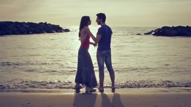 Dois amantes perseguem (correr atrás) e beijando no mar - praia - amor - pôr do sol — Vídeo de Stock