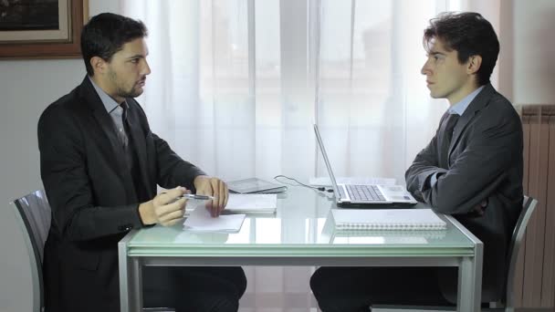 Dos jóvenes hombres de negocios en la reunión, dos hombres de negocios trabajando en el portátil — Vídeos de Stock