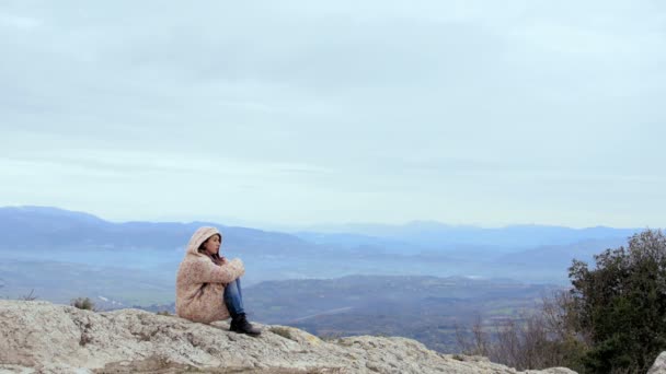 Femme en sweat à capuche, piste de montagne, journée venteuse, cheveux, percing, gros plan — Video