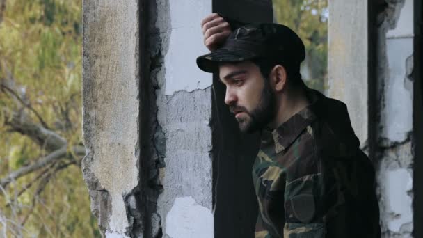 Молодий чоловік, одягнений як солдат, плаче і палить — стокове відео
