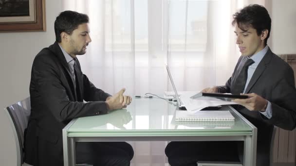 Dos jóvenes hombres de negocios en la reunión, dos hombres de negocios trabajando en el portátil — Vídeo de stock