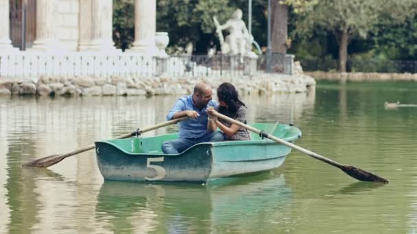 在划艇上恋爱中的人︰ 夫妇在一个小湖中罗马坠入爱河 — 图库视频影像
