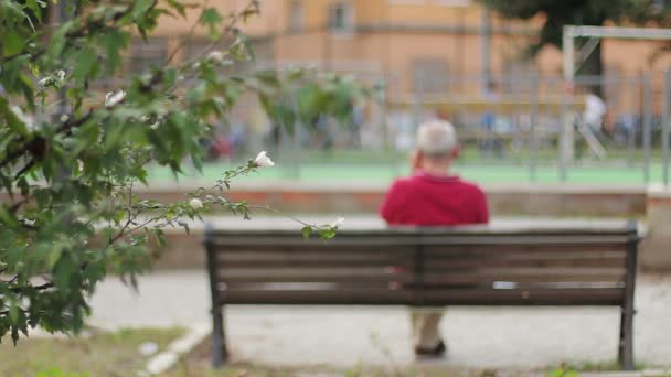 Einsame und traurige alte Männer auf einer Bank mit dem Rücken zur Wand — Stockvideo