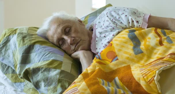 歳女性目を覚ますまでは午前中に、高齢者の女性の目覚め — ストック動画