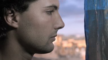 üzgün genç adam pencereden dışarı bakarak