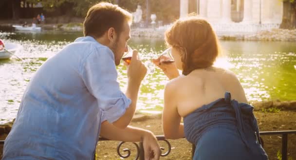 Boire du vin dans une atmosphère romantique près du petit lac : couple, amour, date — Video