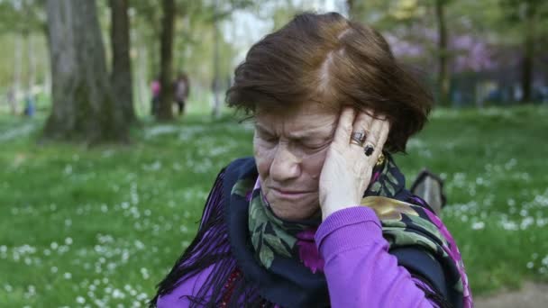 Depressive alte Frau, die allein im Park sitzt: Depressionen, Traurigkeit, alte Frau — Stockvideo