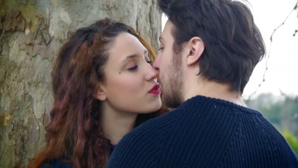 Man and woman kissing outdoor: couple falling in love — Stockvideo