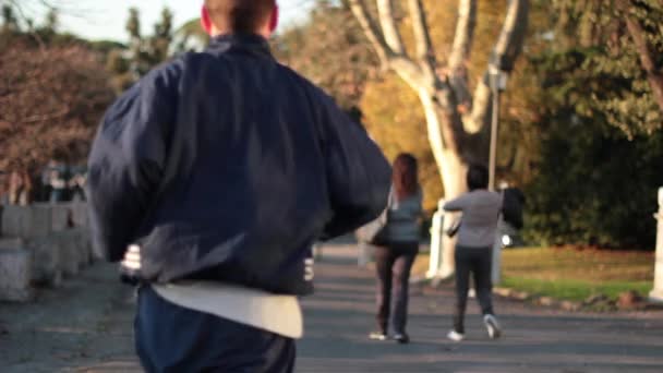 赛跑者在城市公园中在日落时运行 — 图库视频影像