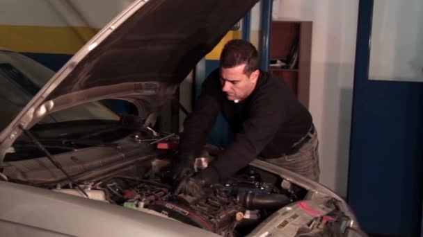 Bilmekaniker reparera en del av en bilmotor — Stockvideo