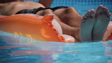 Genç adam bir şilte üzerinde yüzen