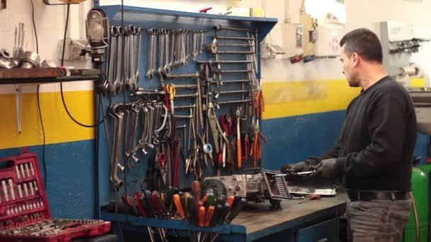 Auto mechanic repairing a part of a car engine — Stock Video