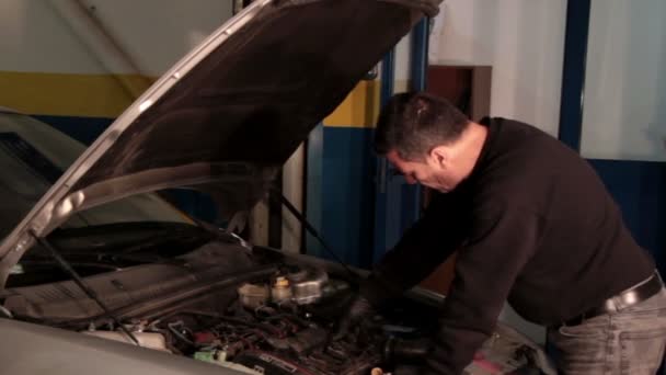 Mecánico de automóviles reparando una parte de un motor de coche — Vídeo de stock