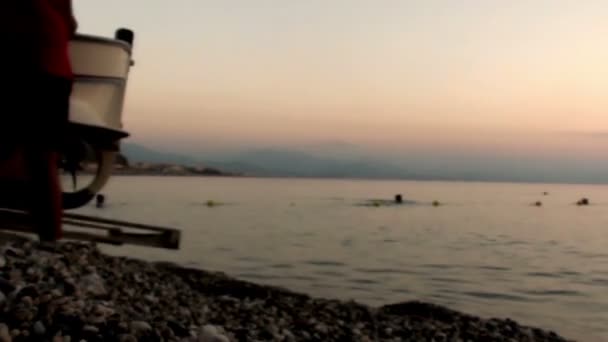 孤独な漁師は日没で釣りに行く水にボートを置く — ストック動画