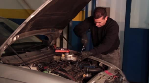 Mécanicien automobile réparant une partie d'un moteur de voiture 