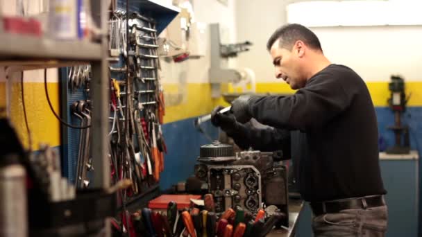 Auto mechanic repairing a part of a car engine — Stock Video