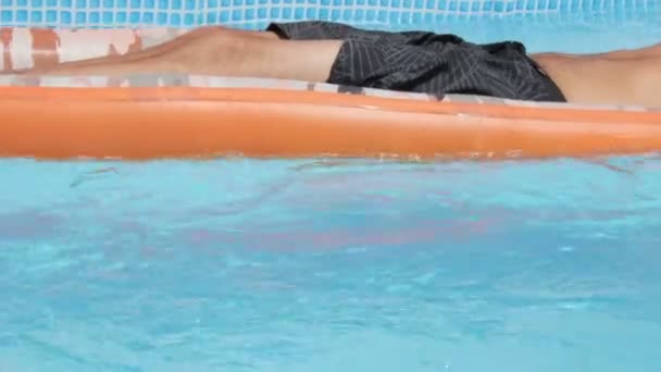 Молодий чоловік плаває на матраці — стокове відео