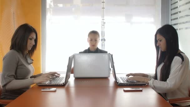 Trabajo en equipo: mujeres de negocios que trabajan en la oficina con ordenadores personales: ordenador portátil — Vídeo de stock