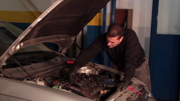 Mécanicien automobile réparant une partie d'un moteur de voiture — Video
