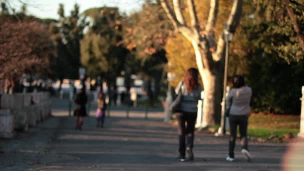 Pessoas caminhando ao pôr do sol em um parque de Roma — Vídeo de Stock